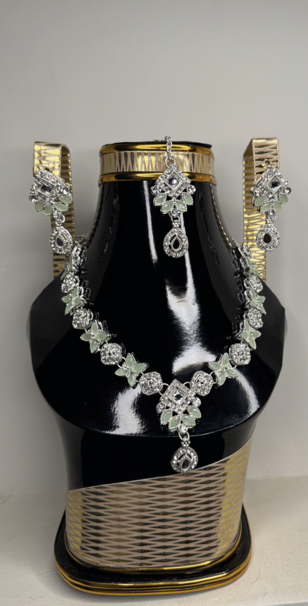 A zircon necklace and earrings displayed on a black mannequin, showcasing their elegant design and sparkling details.